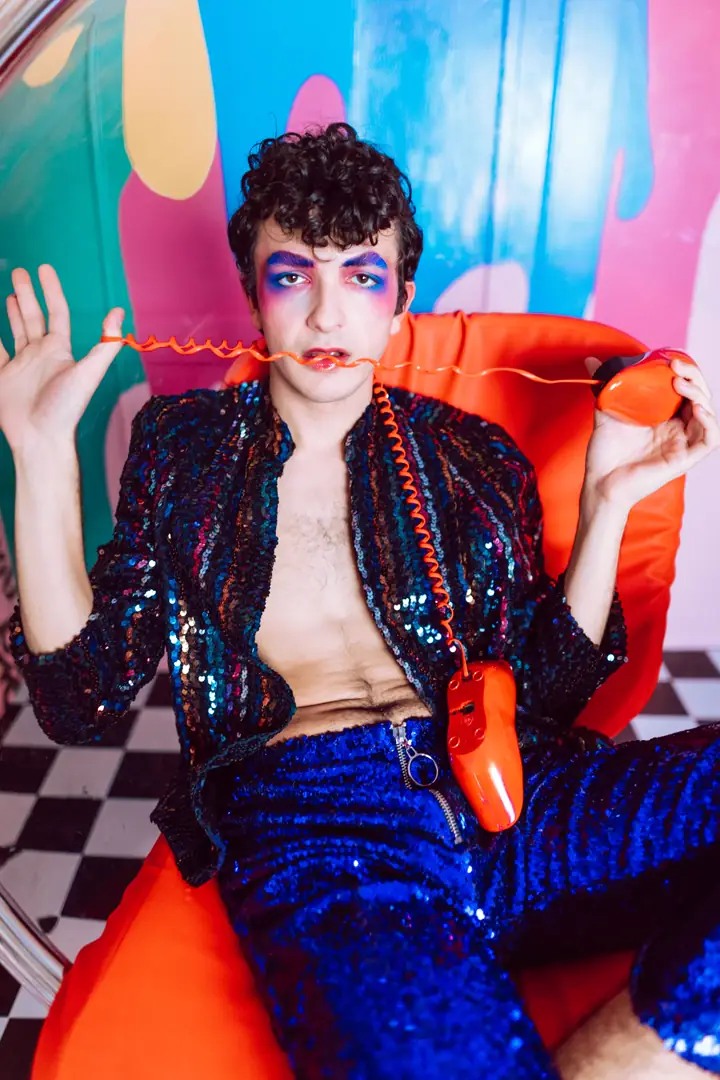 A bold editorial portrait with colourful makeup and a retro telephone